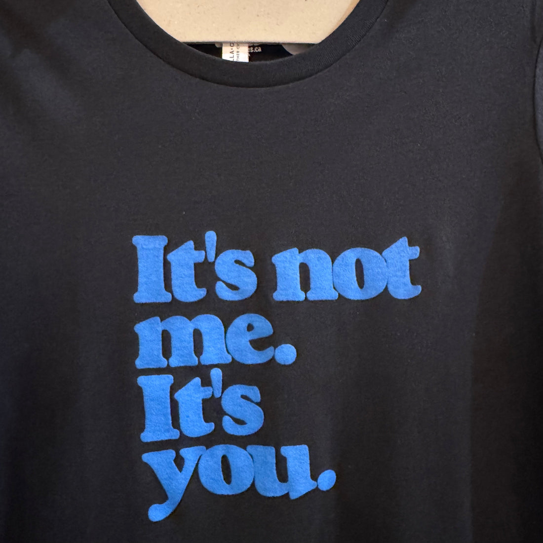minimal typography t shirt with “It’s not me. It’s you.” text design in blue on black tee